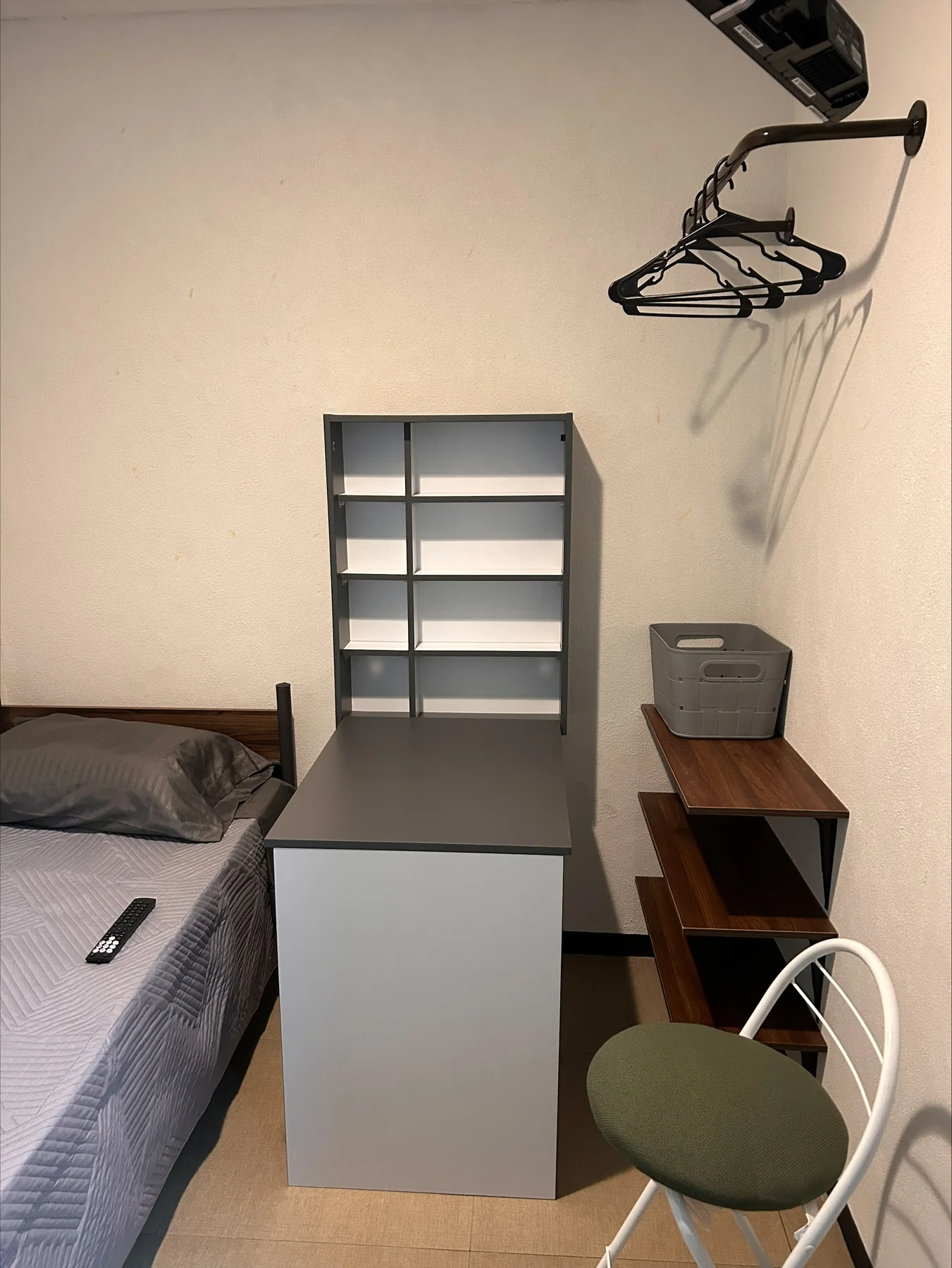 Habitación con escritorio central, silla y cama