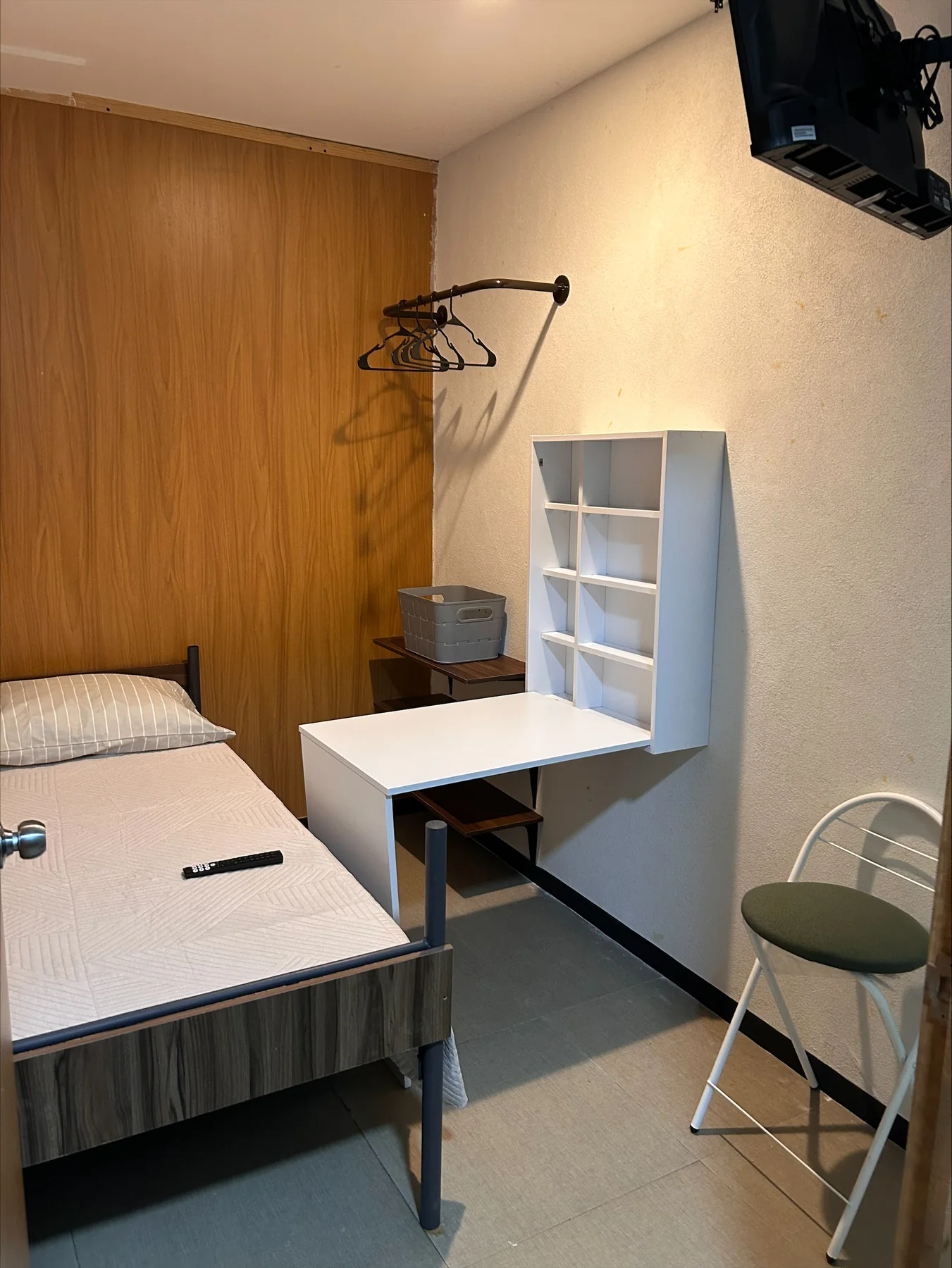Habitación con escritorio lateral, estantería y cama