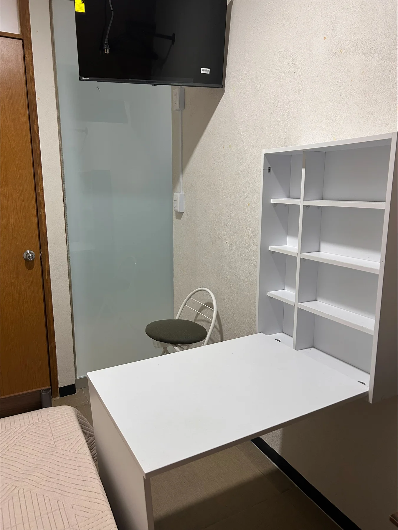 Habitación equipada con escritorio, silla, televisión y estantería