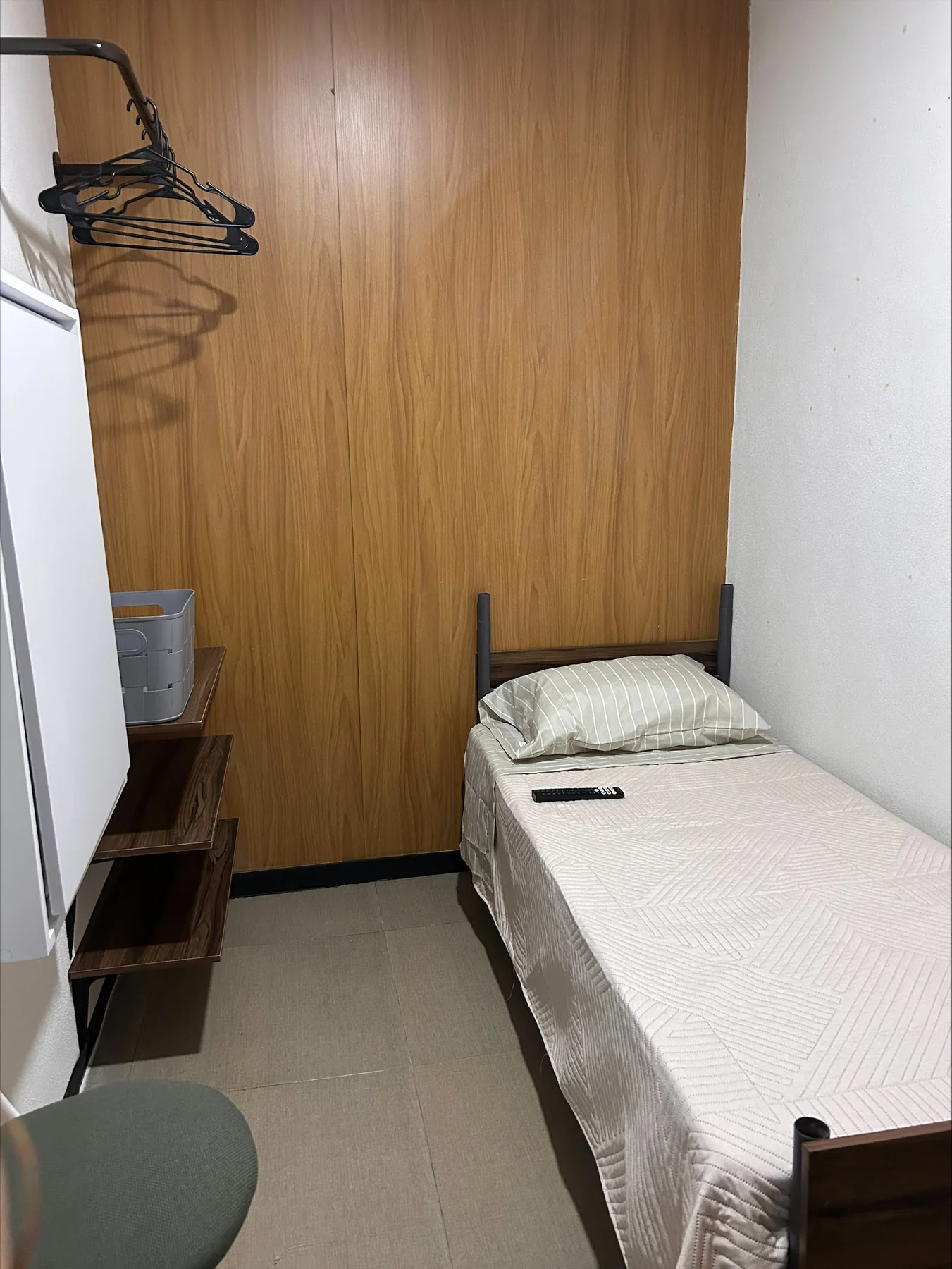Habitación individual con muro de madera y cama