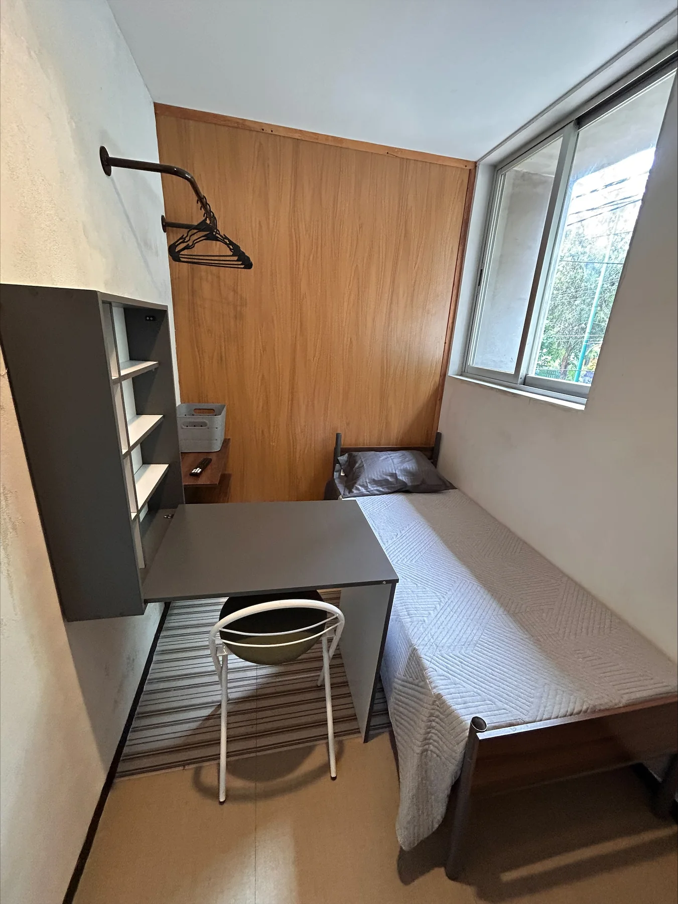 Habitación con ventana, escritorio, silla y cama